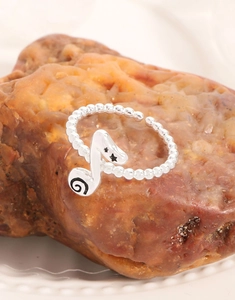 Macro view of adjustable S925 sterling silver beaded ring with music note detail