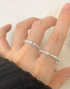 Detail of S925 sterling silver heart ring and irregular ring with pearl inlay on finger
