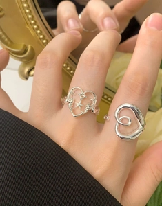 Close-up of S925 sterling silver hollow heart ring and minimalist spiral heart design
