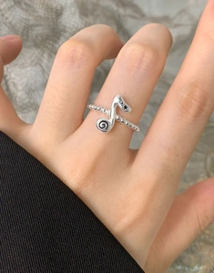 Detailed view of S925 silver music note ring with black star on beaded band