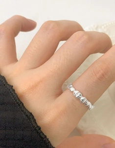 Macro shot of S925 sterling silver heart ring worn on finger with lace background