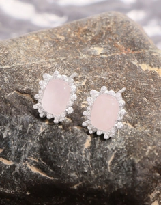 Macro view of rose quartz stud earrings with irregular textured silver frames