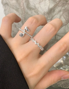 Detail of S925 silver music note ring with black micro-diamonds on model hand