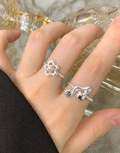 Close-up of S925 sterling silver music note and flower open rings on a model hand