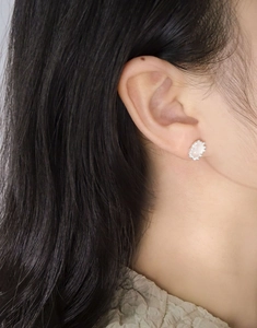 Close-up of S925 silver pink crystal stud earring worn on ear with halo diamonds