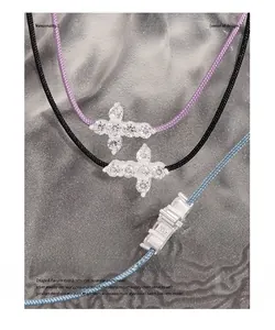Macro detail of S925 sterling silver cross pendant with pavé cubic zirconia on braided cords