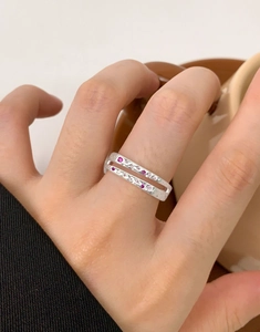 Detail of double-layer S925 silver ring with pink zircon stones on woman hand