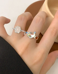 Close-up of S925 silver rings with heart-shaped iridescent and oval pink crystals