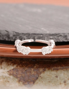 Detailed close-up of 925 sterling silver floral ring clusters on a rustic dark stone background