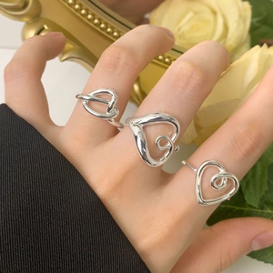 Three minimalist S925 sterling silver heart-shaped rings set displayed on finger