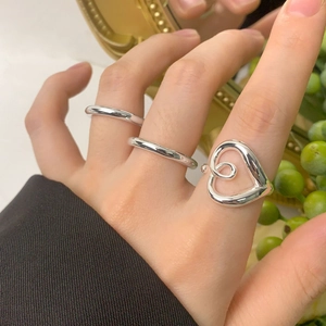 Elegant S925 sterling silver hollow heart ring set shown on model hand with a vintage background