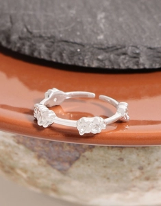 Detailed view of adjustable silver bear cluster ring on a ceramic display base