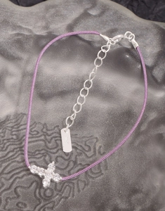 Detail view of purple braided bracelet with zircon butterfly and S925 silver tag