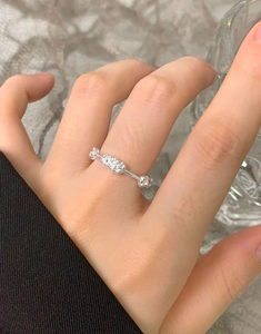 Detail of S925 sterling silver floral cluster ring with cubic zirconia worn on hand