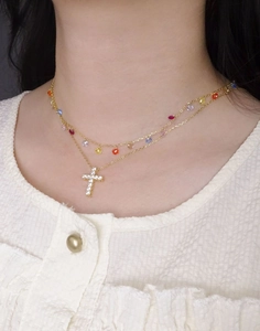 Détail du collier à étages avec croix en zircon doré et perles de pierres colorées