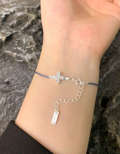 Close-up of S925 sterling silver hallmark on blue zircon cross braided rope bracelet