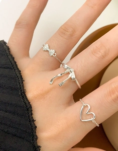 Close-up of S925 sterling silver ring set featuring bow and heart chain designs