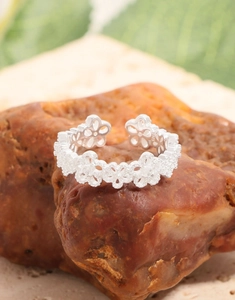 Detailed view of S925 sterling silver lace flower ring on natural red stone background