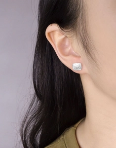 Detail view of square geometric S925 sterling silver stud earring on female model