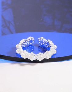 Detailed macro view of S925 sterling silver lace ring featuring white pearls on a blue stand