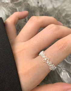 Detailed view of an S925 sterling silver lace flower ring worn on a finger