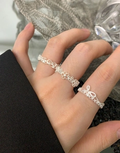 Détail des bagues en argent fin S925 avec motifs de dentelle fleurie et de nœud
