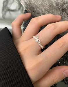 Gros plan d'une bague nœud en argent S925 affichant un design en dentelle ajourée