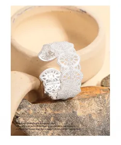 Close-up of S925 sterling silver lace ring with intricate hollow floral design on a rock
