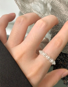 Detail of S925 silver lace ring with five round pearls worn on a female finger