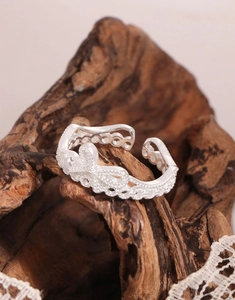 Gros plan sur bague nœud en argent S925 avec dentelle délicate et cristaux brillants