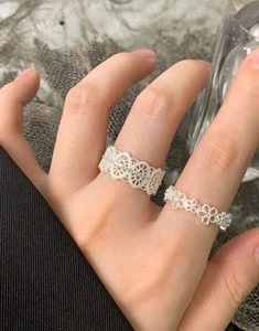 Detailed view of two vintage S925 sterling silver lace rings with zircon on fingers