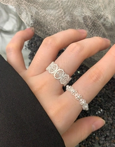 Detail of S925 silver lace hollow ring and delicate pearl band set on a finger