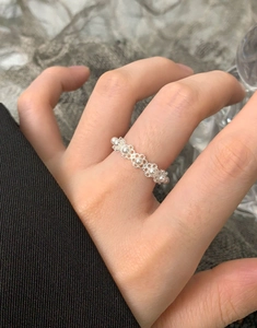Detail of S925 silver lace ring with white pearls worn on finger in elegant setting