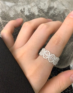 Close-up of S925 sterling silver lace ring with hollow heart pattern worn on hand