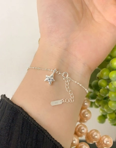 Dettaglio del bracciale in argento sterling S925 con pendente a stella indossato al polso