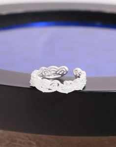 Macro shot of silver lace crown ring featuring intricate cutout vine patterns and textures