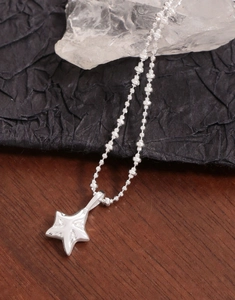 Dettaglio del ciondolo a stella in argento S925 con trama irregolare su collana