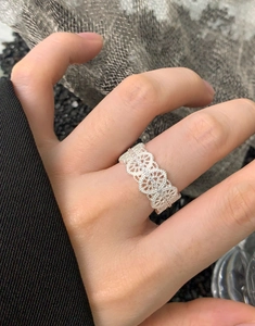 Detailed close-up of S925 sterling silver ring with hollow lace pattern on a finger