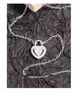 Macro detail of S925 sterling silver heart lock pendant with sparkling zircon on cross chain