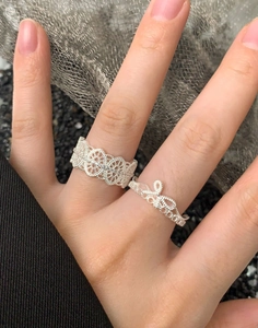 Macro detail of S925 sterling silver lace ring and bow ring in vintage floral design