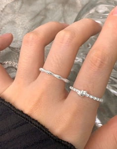 Macro shot of S925 sterling silver hammered wave ring and knotted texture band