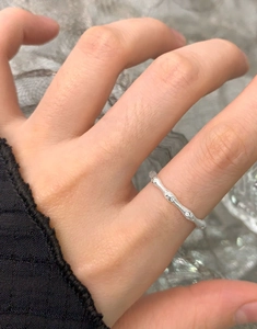 Macro shot of minimalist S925 sterling silver branch ring with textured finish and zircon