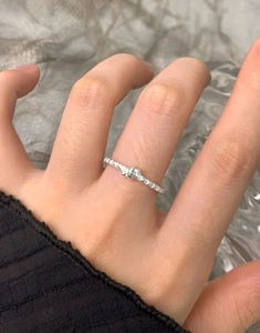 Detail shot of a minimalist S925 sterling silver star knot ring on a finger