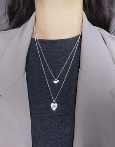 Close-up of double layer S925 silver shell heart pendant necklace on a grey blazer