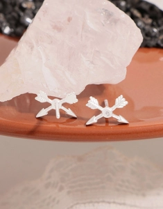 Macro shot of S925 sterling silver arrow stud earrings with white cubic zirconia inlay