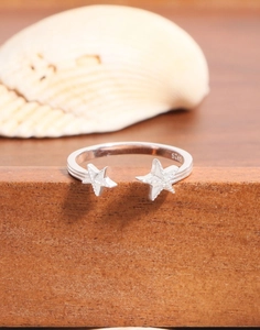 Macro shot of S925 sterling silver starfish ring with engraved stamp on wooden stand