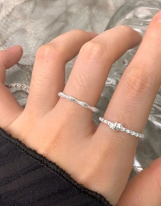 Macro view of S925 sterling silver knot ring and wavy zircon ring on model hand