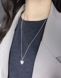 Close-up of S925 sterling silver shell heart necklace with textured engraving on model