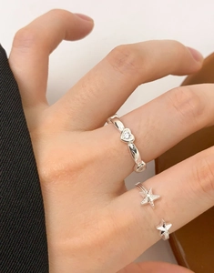 Close-up of S925 sterling silver rings with heart gemstone and starfish design details