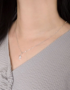Close-up of minimalist S925 sterling silver star pendant necklace worn on neck